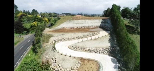 Aerial view of a winding driveway with boulder retaining walls